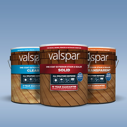 Trio of gallon cans of Valspar exterior stains in clear, solid and semi-transparent  against a soft blue background.