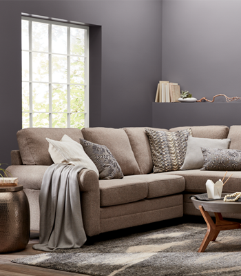 Living room with couch, window, hanging art and small coffee table.